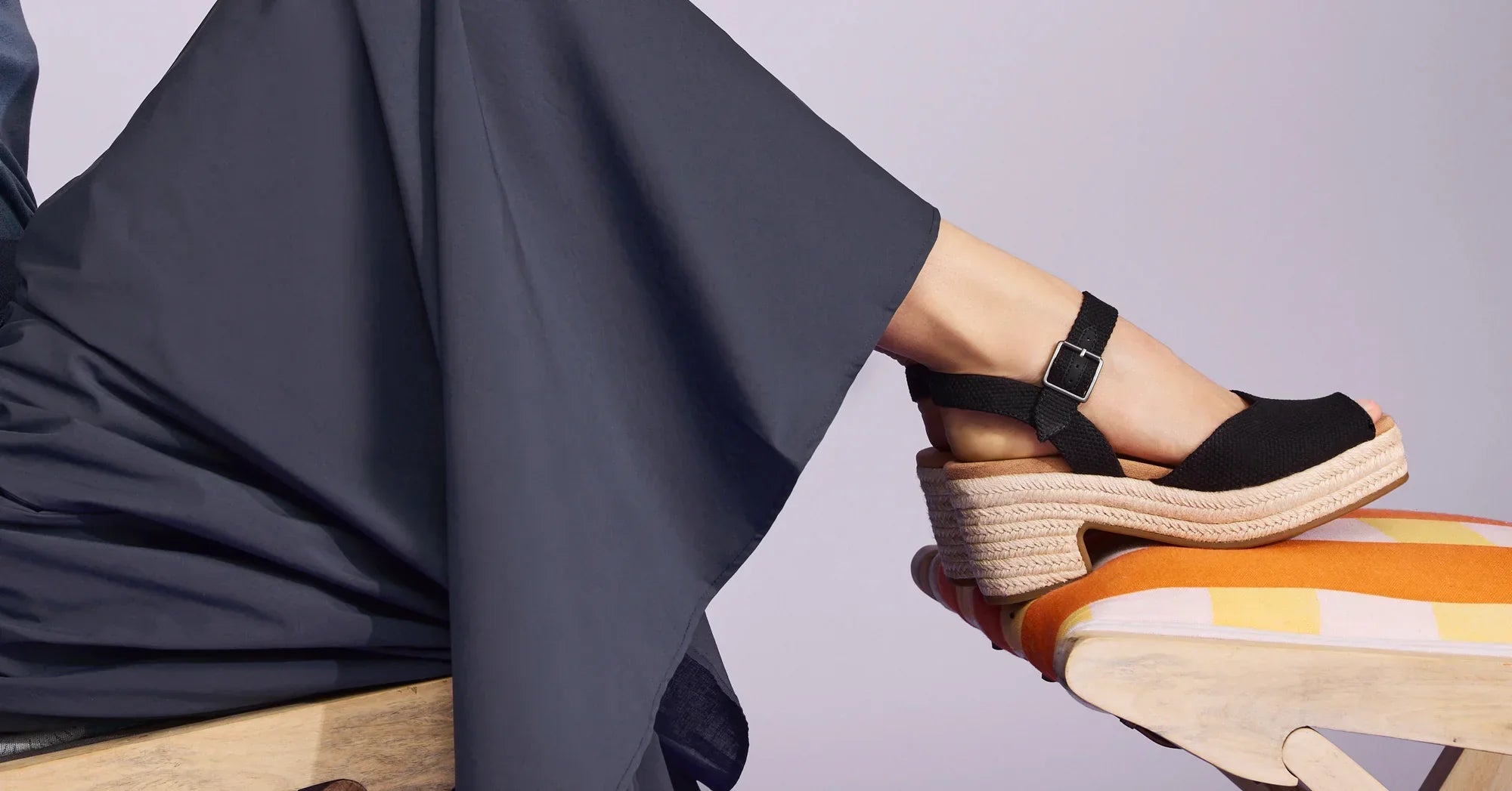 Model wearing Isla Peep Toe Heeled Sandal in black beachside woven shown.