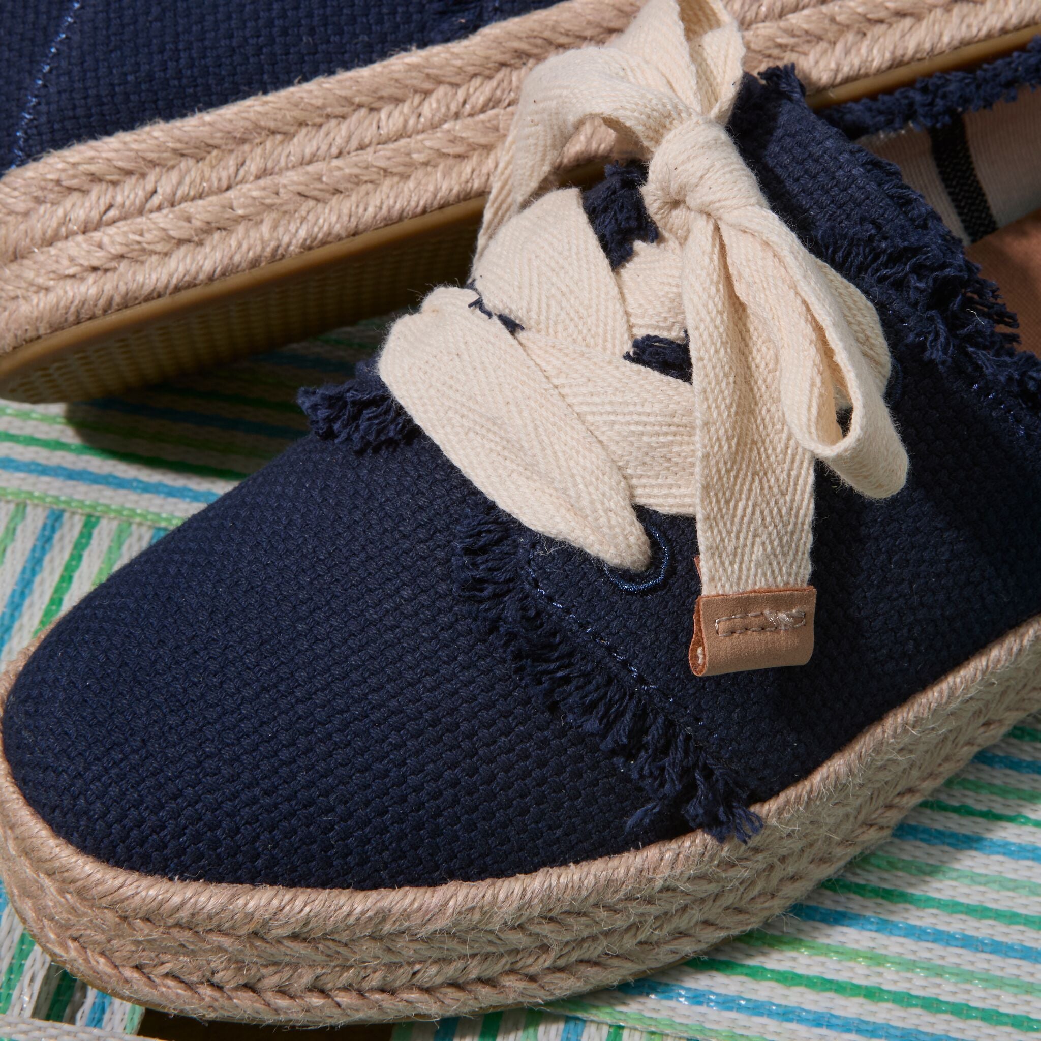 Up close detail shot of the navy frayed Carolina lace up espadrille