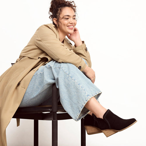 kaia wedge boot with tonal deco stitching on model sitting in chair