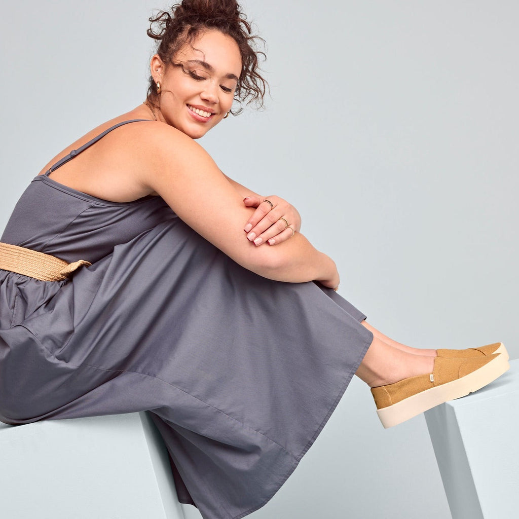 verona slip on platform sneaker in gold on model styled with dress