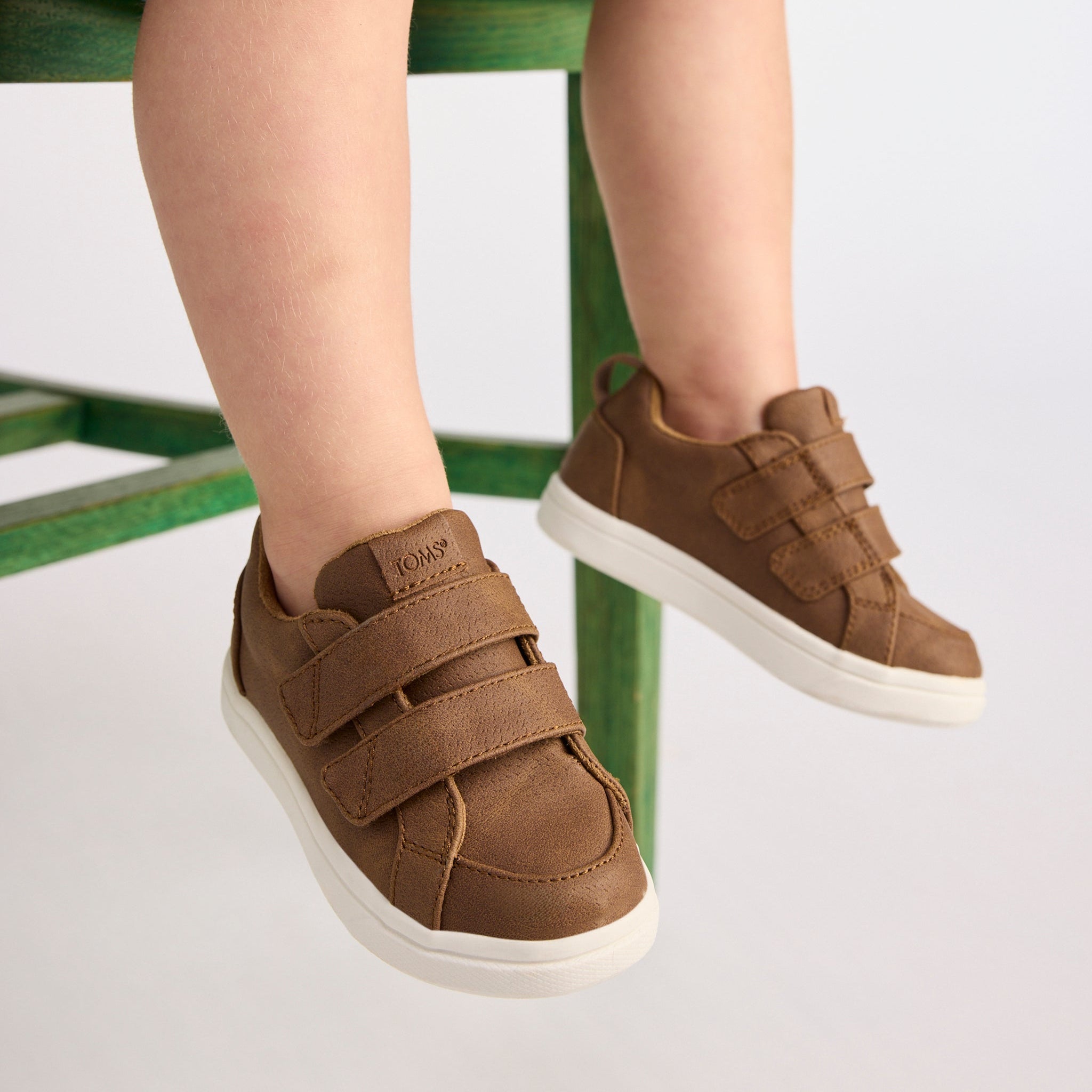 On figure image of the Cruz Double Strap Toddler Shoe in Toffee Microsuede