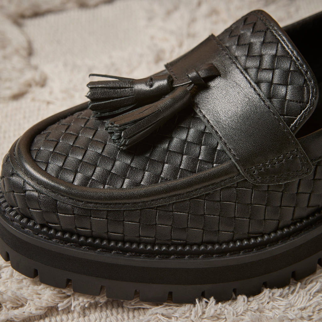 Up close detail shot of the black faux leather woven tassel Cara loafer