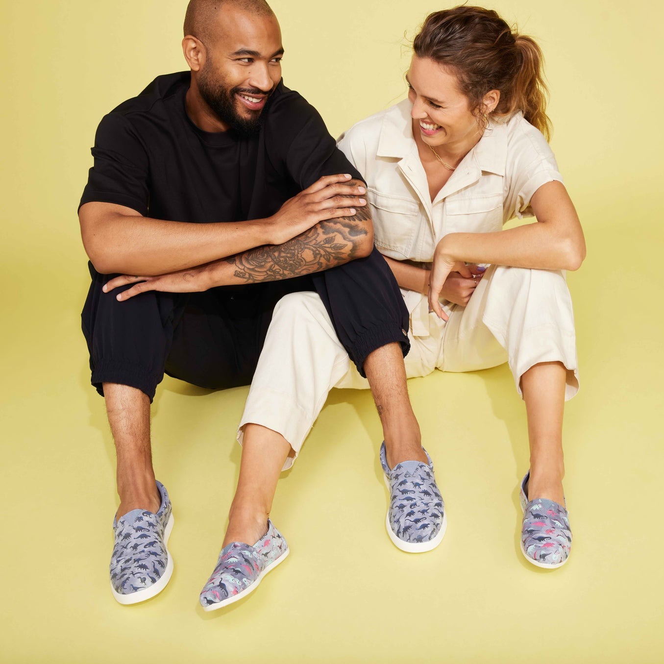 Men'S Glow In The Dark Dino Print On Model Sitting With Woman Also Wearing Dino Print Alpargata Shoes