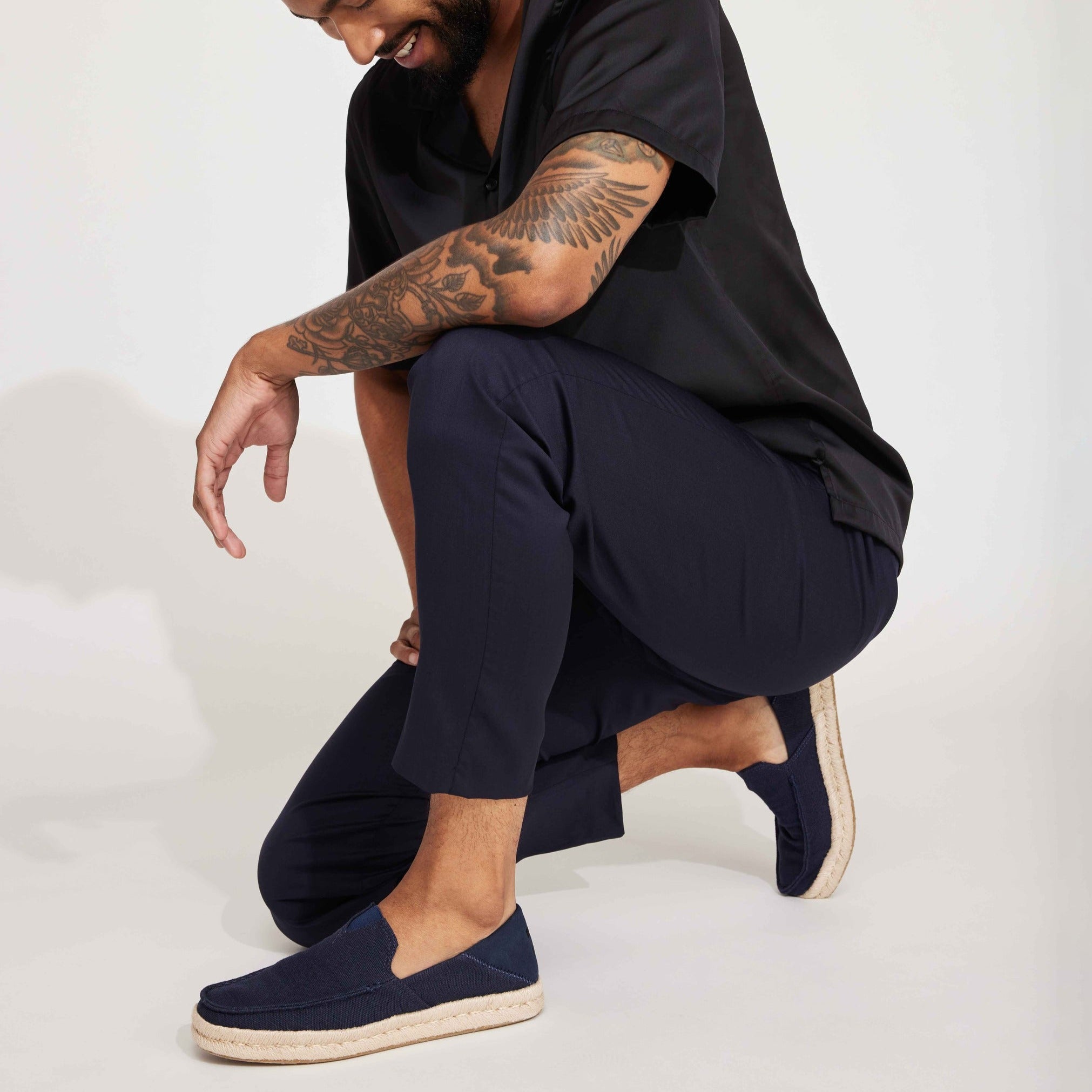 Alonso Rope Sole Moc Toe Loafer Slip On With Collapsible Heel On Model Squatting Against White Background