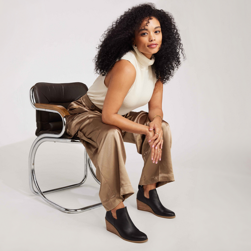 Black Leather Kallie Ankle Boot On Model Sitting In Chair