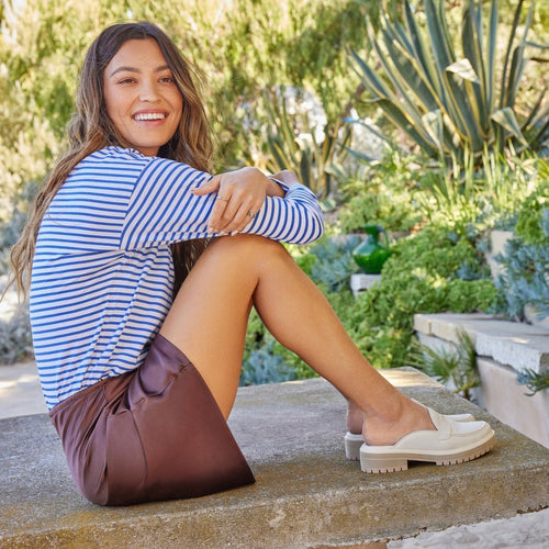 cara mule loafer in sand on model relaxing in nature