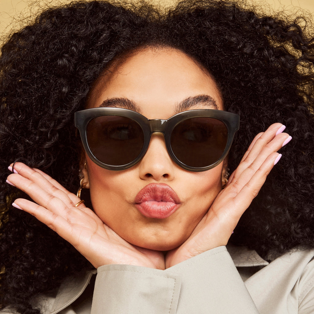 women's florentin traveler sunglasses in dark green frames with grey lenses up close on model detail shot