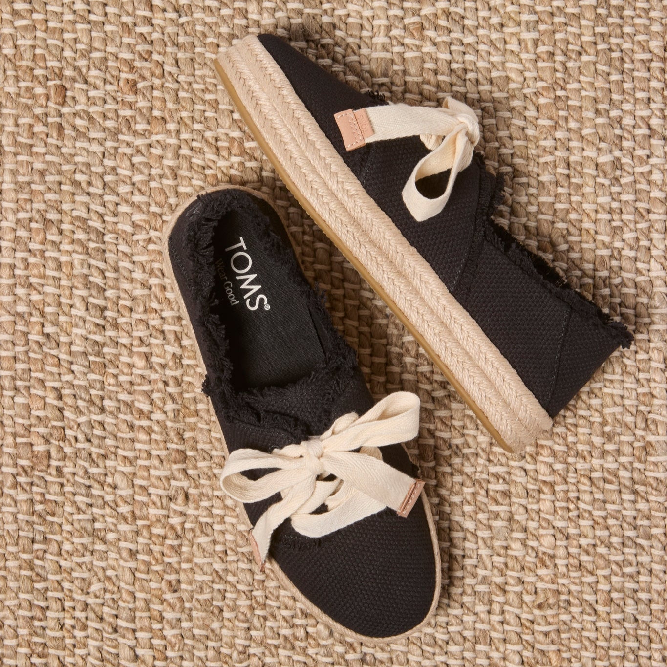 Laydown image of the black beachside woven lace up Carolina Espadrille
