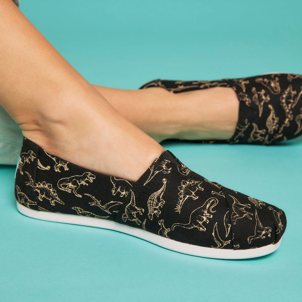 Close Up Detail Shot Of Glow In The Dark Dinosaur Black Canvas Slip On Alpargata Shoe